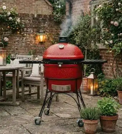 Kamado rosso acceso accanto a un tavolo apparecchiato