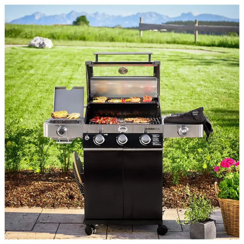 Barbecue a gas a quattro fuochi con piano laterale sul prato