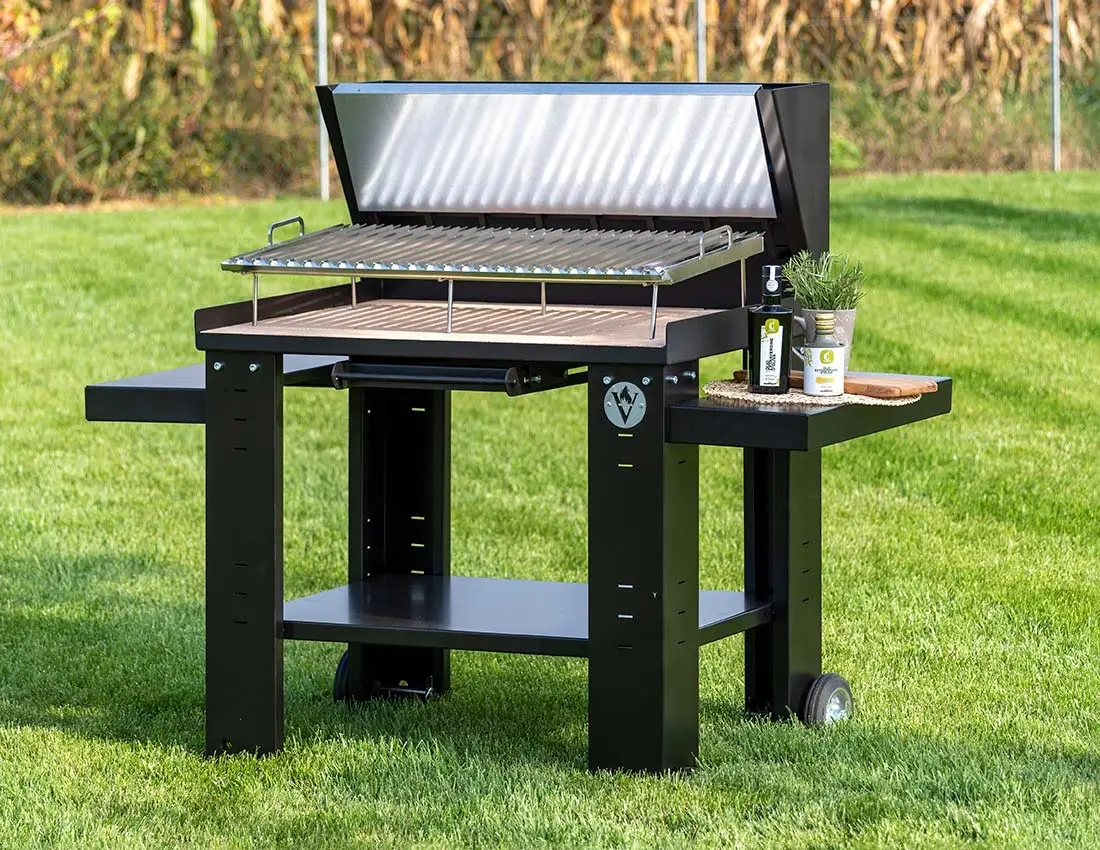 Barbecue a carbone con coperchio e piani laterali sul prato